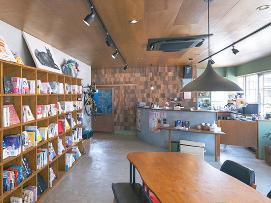 [写真]約500冊の蔵書の中には、デザインやアート関連の本もたくさん。　店内には、佐藤さんがこれまで手掛けた作品たちも展示されています。