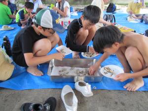 川魚の天ぷらをとっている子どもたちの写真です。